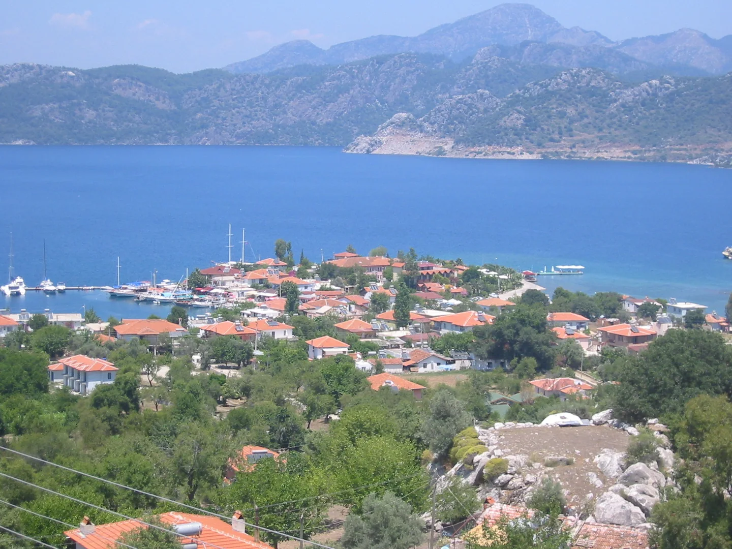 Selimiye village, its small harbour and waterfront on a blue bay backed by hills.