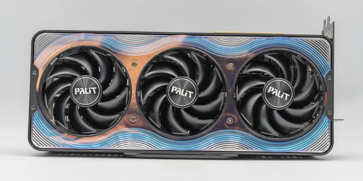 A Palit GeForce RTX 5090 GameRock graphics card seen from the front: three black fans side by side on one shroud with a blue and copper pattern