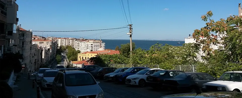 Ένας δρόμος στη Σμύρνη που ανηφορίζει από τη θάλασσα, με αυτοκίνητα σταθμευμένα κατά μήκος του