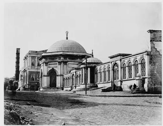 Black-and-white photograph of the domed tomb of Mahmud II on a street, with a row of arched windows beside it