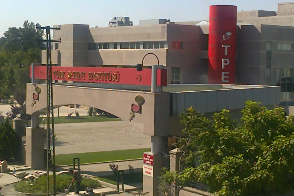 L&rsquo;entr&eacute;e du b&acirc;timent de T&Uuml;RKPATENT &agrave; Ankara&nbsp;: un portail en arc surmont&eacute; d&rsquo;une enseigne rouge, une tour rouge portant les lettres TPE et un grand immeuble de bureaux gris &agrave; l&rsquo;arri&egrave;re-plan