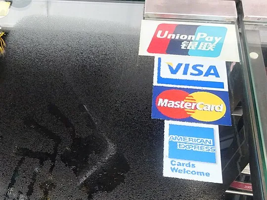 Bir mağaza vitrininde d&ouml;rt kart ağına ait etiketler: UnionPay, Visa, Mastercard ve &ldquo;Kartlar ge&ccedil;erlidir&rdquo; yazılı American Express