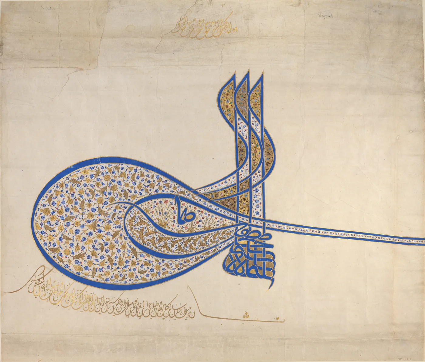Photographie d’une seconde feuille de tugra avec les cinq mêmes parties : trois hampes, deux ovales emboîtés, une longue bande vers la droite, des traits recourbés et un bloc de lettres superposées, en bleu et or