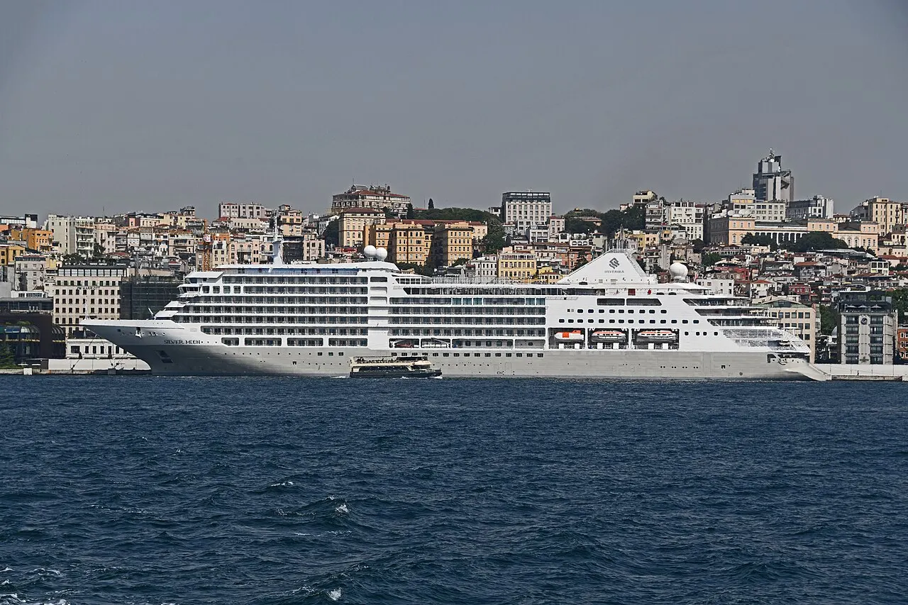 Foto: la nave da crociera bianca Silver Moon accostata a Galataport sul Bosforo, con la collina di Beyoğlu sullo sfondo.